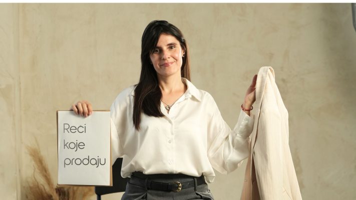 marija sedi i drzi papir na kome pise Reci koje prodaju u jednoj ruci dok u drugoj drzi sako